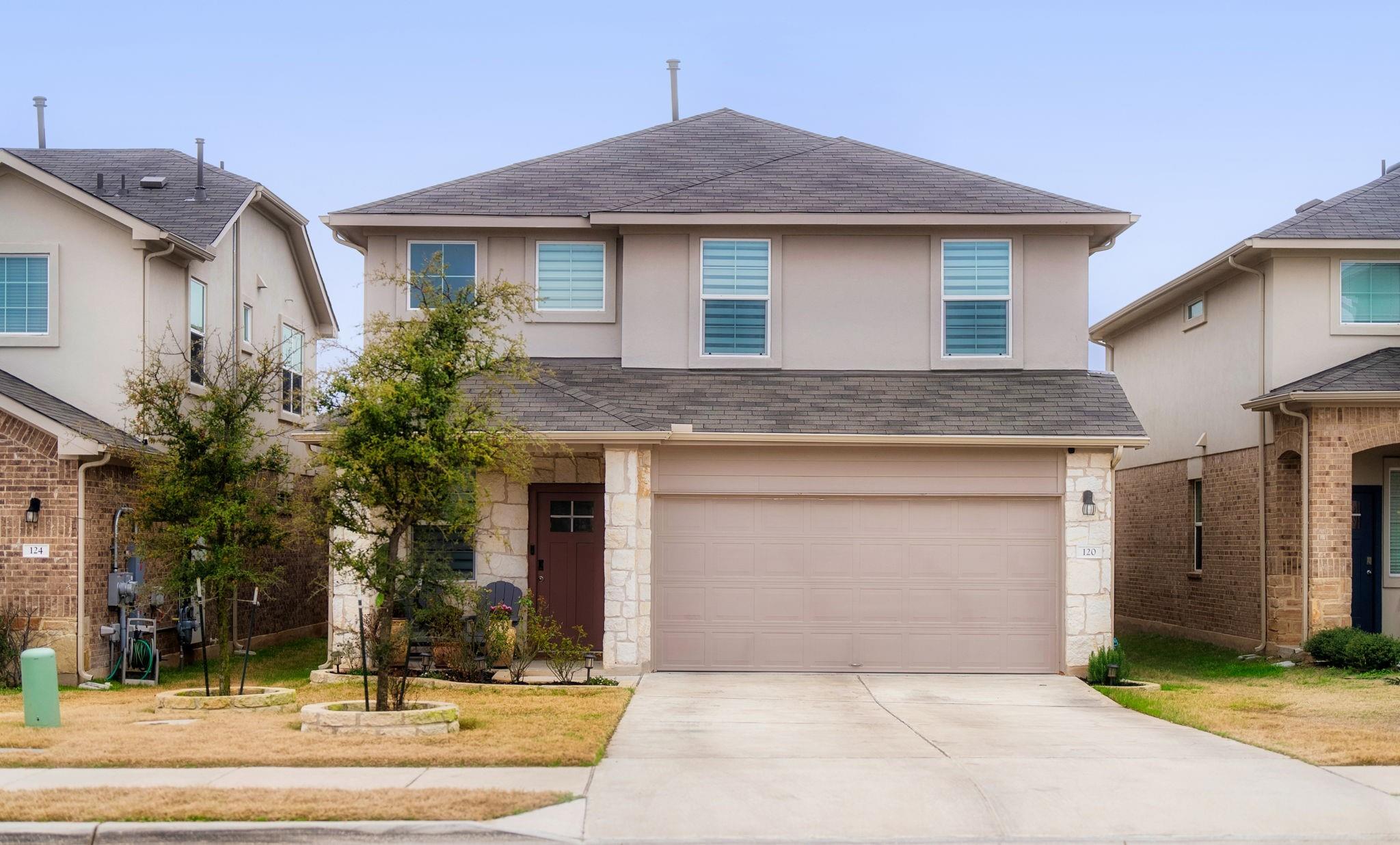 Traditional-style house featuring roof with shingles, stone siding, concrete driveway, and an attached garage