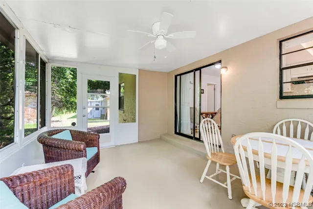 a living room with furniture and two large window