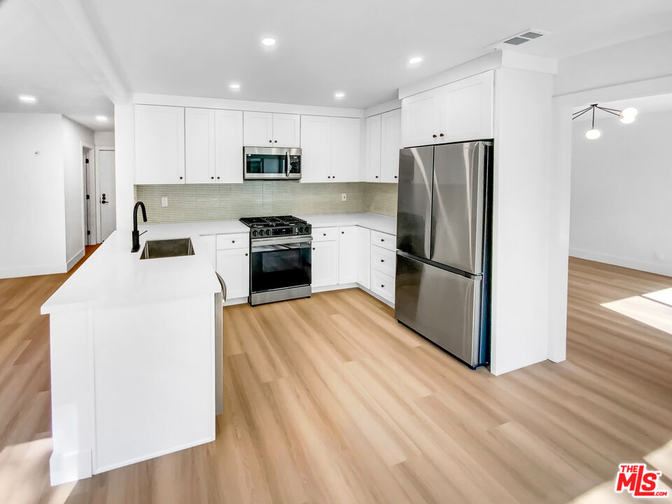 830 Vía Alameda San Dimas, CA 91773 - Photo 13 of 31 a kitchen with a refrigerator a stove top oven and wooden floor