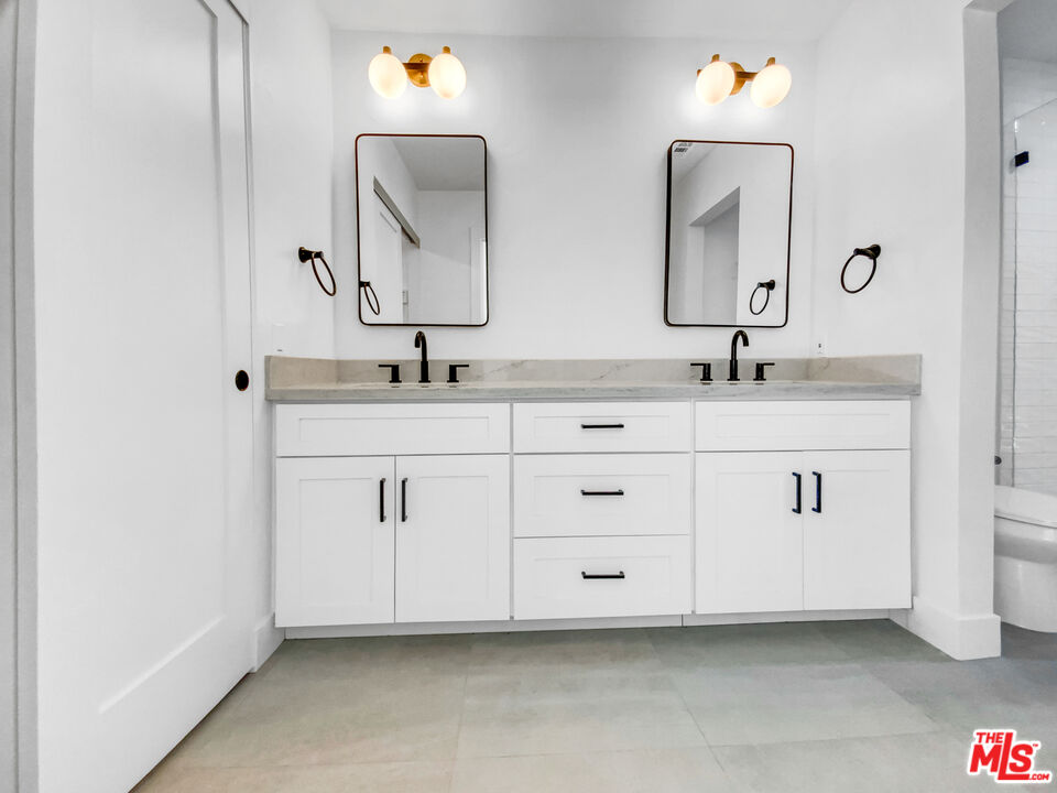 830 Vía Alameda San Dimas, CA 91773 - Photo 29 of 31 a bathroom with a double vanity sink and a mirror