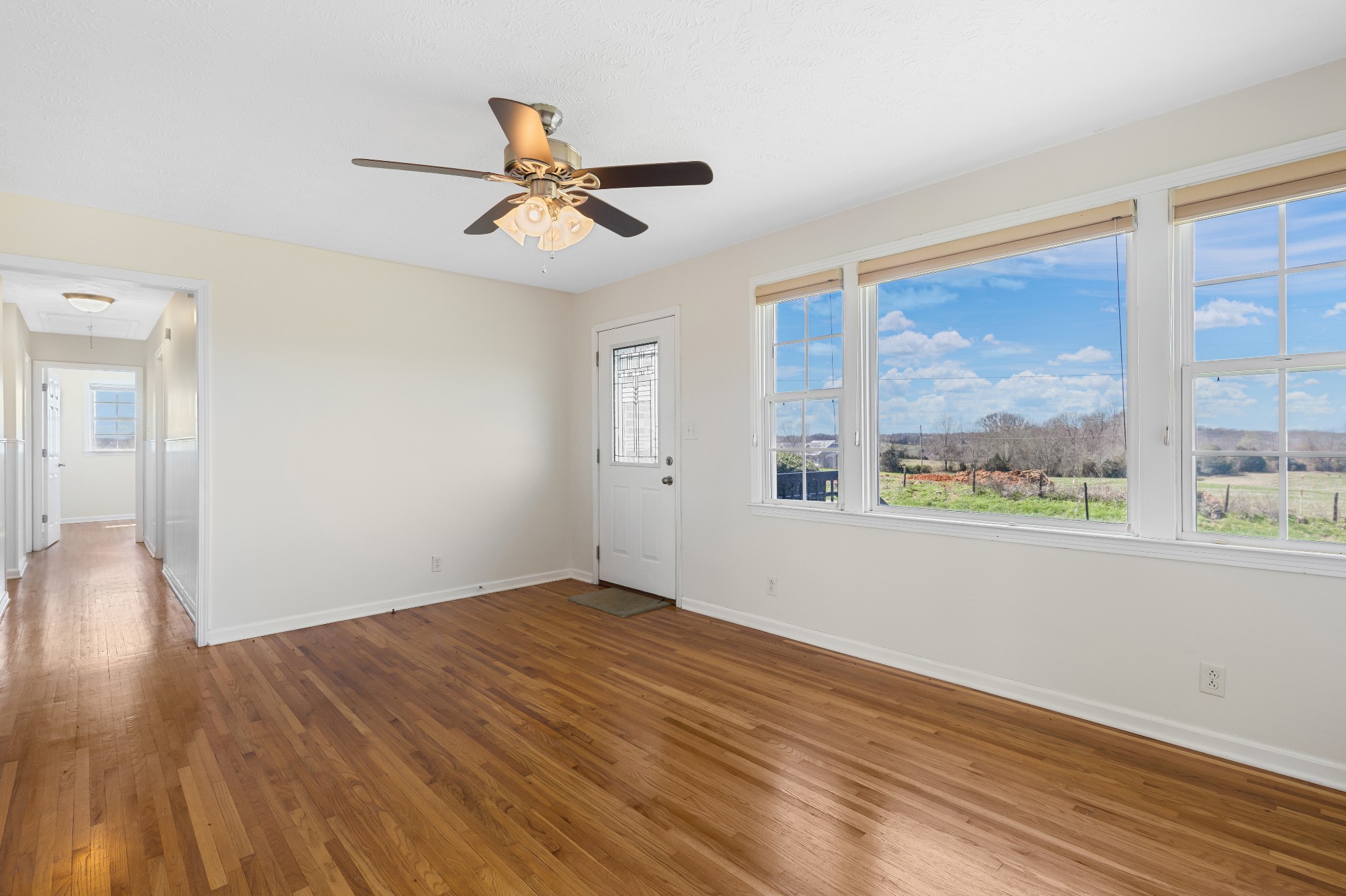 6035 Buzzard Creek Road Cedar Hill, TN 37032 - Photo 9 of 42 an empty room with wooden floor fan and windows