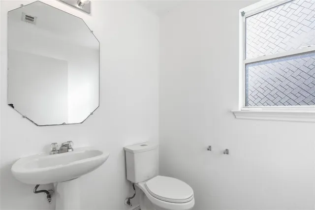a bathroom with a sink toilet and mirror