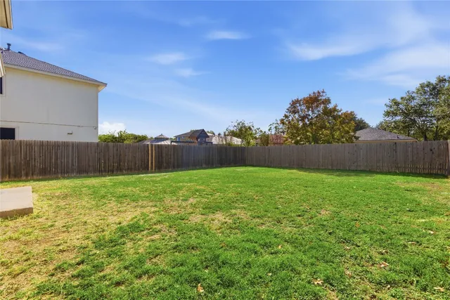 a view of yard with swimming pool and wooden fence