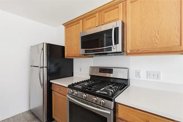 a kitchen with stainless steel appliances a stove a microwave and a refrigerator