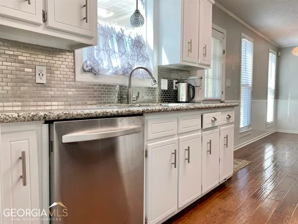 a kitchen with granite countertop white cabinets and white stainless steel appliances