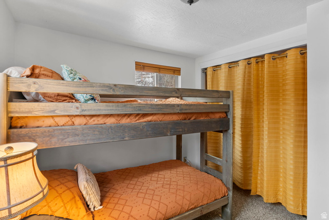 2189 Samak Park Loop, Unit 43 Kamas, UT 84036 - Photo 31 of 48 Bedroom featuring a textured ceiling, a closet, and carpet