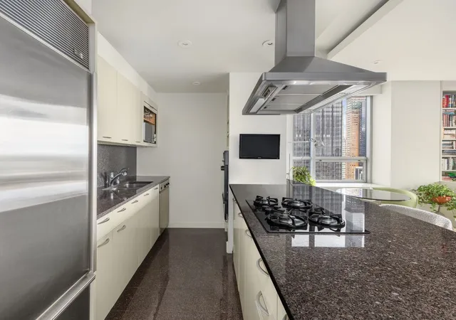 a kitchen with stainless steel appliances granite countertop a sink stove and cabinets