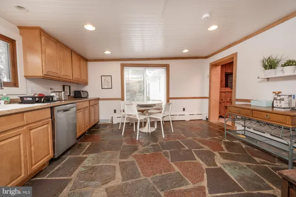 a kitchen with a dining table chairs and white cabinets