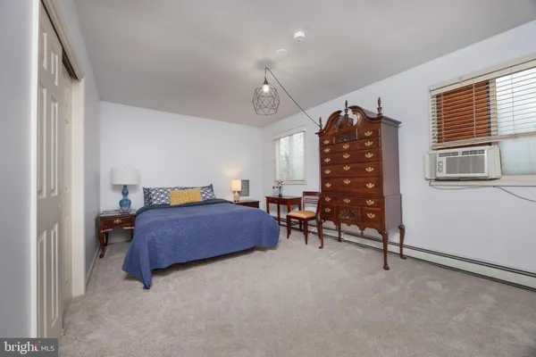 a bedroom with a bed a chair and a chandelier