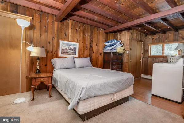 a bedroom with a bed next to a mirror and a shower