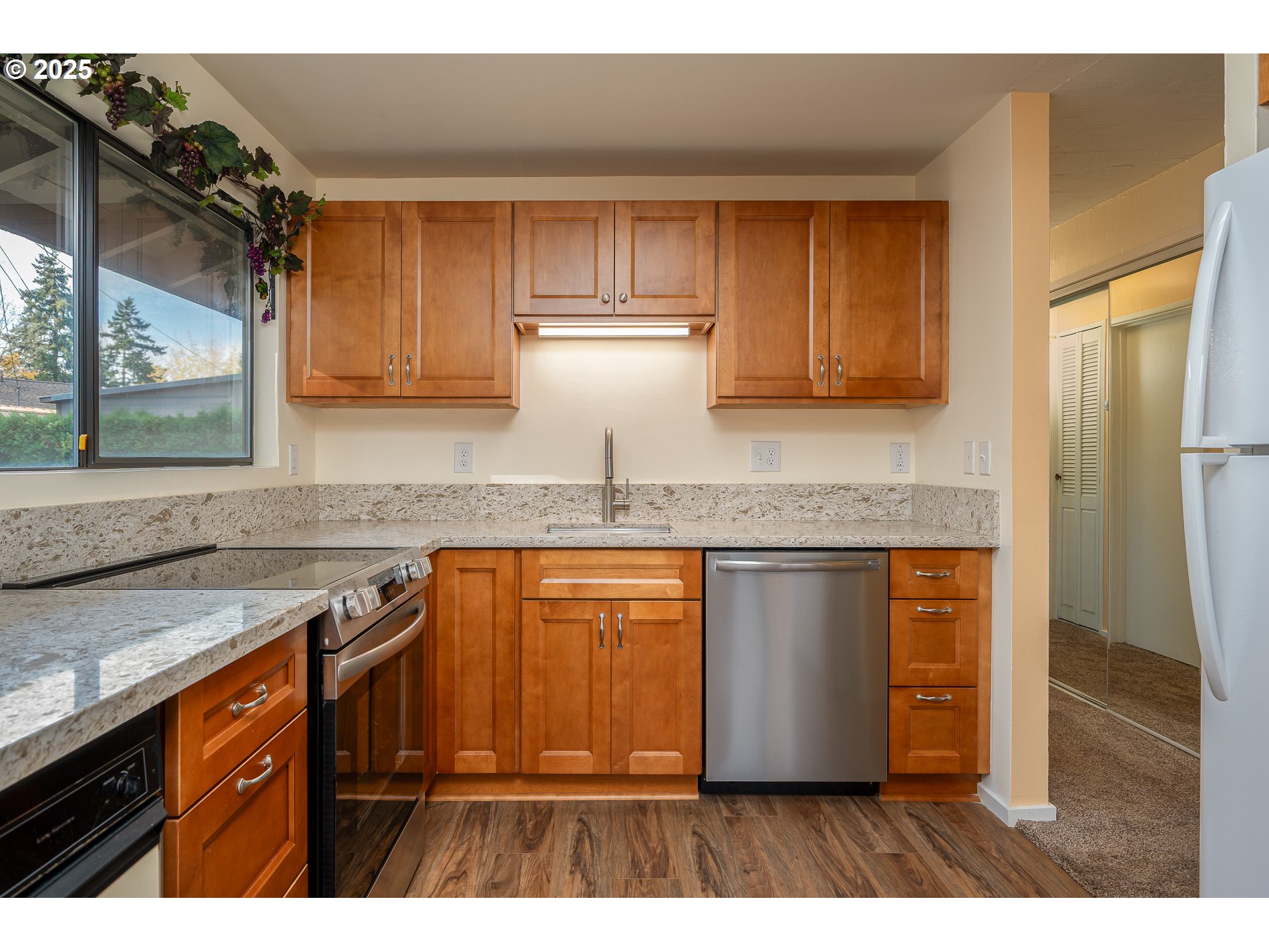 13020 Northeast San Rafael Street Portland, OR 97230 - Photo 10 of 35 a kitchen with granite countertop wooden cabinets a sink and dishwasher