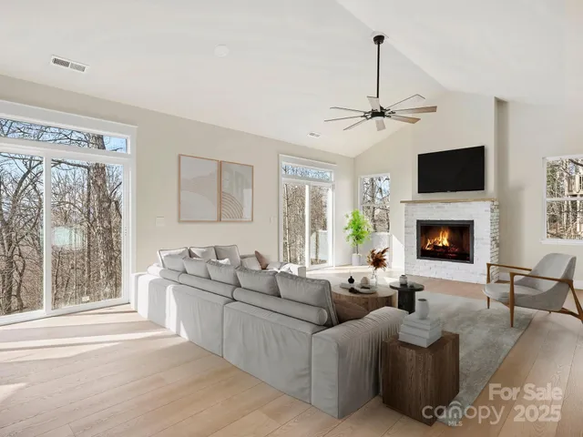 a kitchen with stainless steel appliances a sink a stove a kitchen island with a dining table and chairs