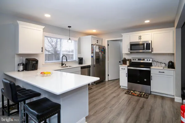 a kitchen with a refrigerator a stove a sink dishwasher with a dining table and chairs