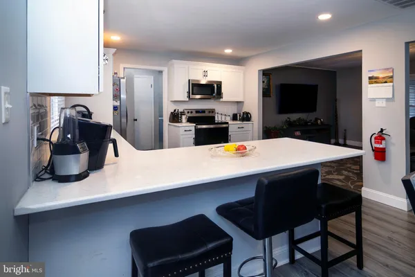 a kitchen with a table chairs refrigerator and microwave