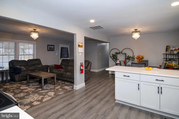 a living room with furniture a dining table and wooden floor