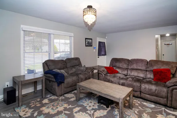 a living room with furniture a chandelier and a window