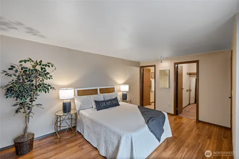 a bedroom with a large bed and a potted plant