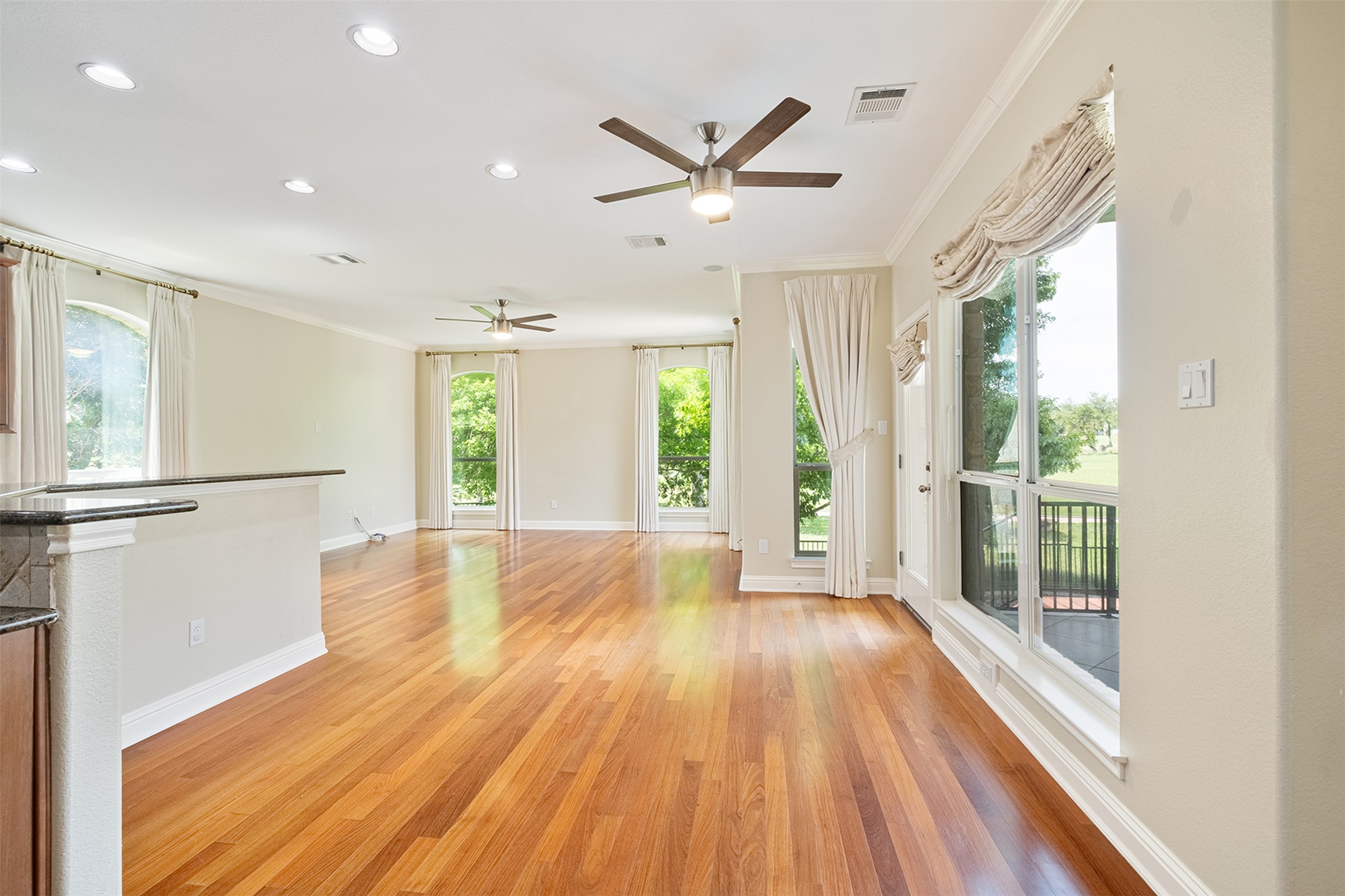 14909 Spillman Ranch Loop Austin, TX 78738 - Photo 11 of 40 Unfurnished living room featuring a ceiling fan, crown molding, visible vents, and light wood-type flooring