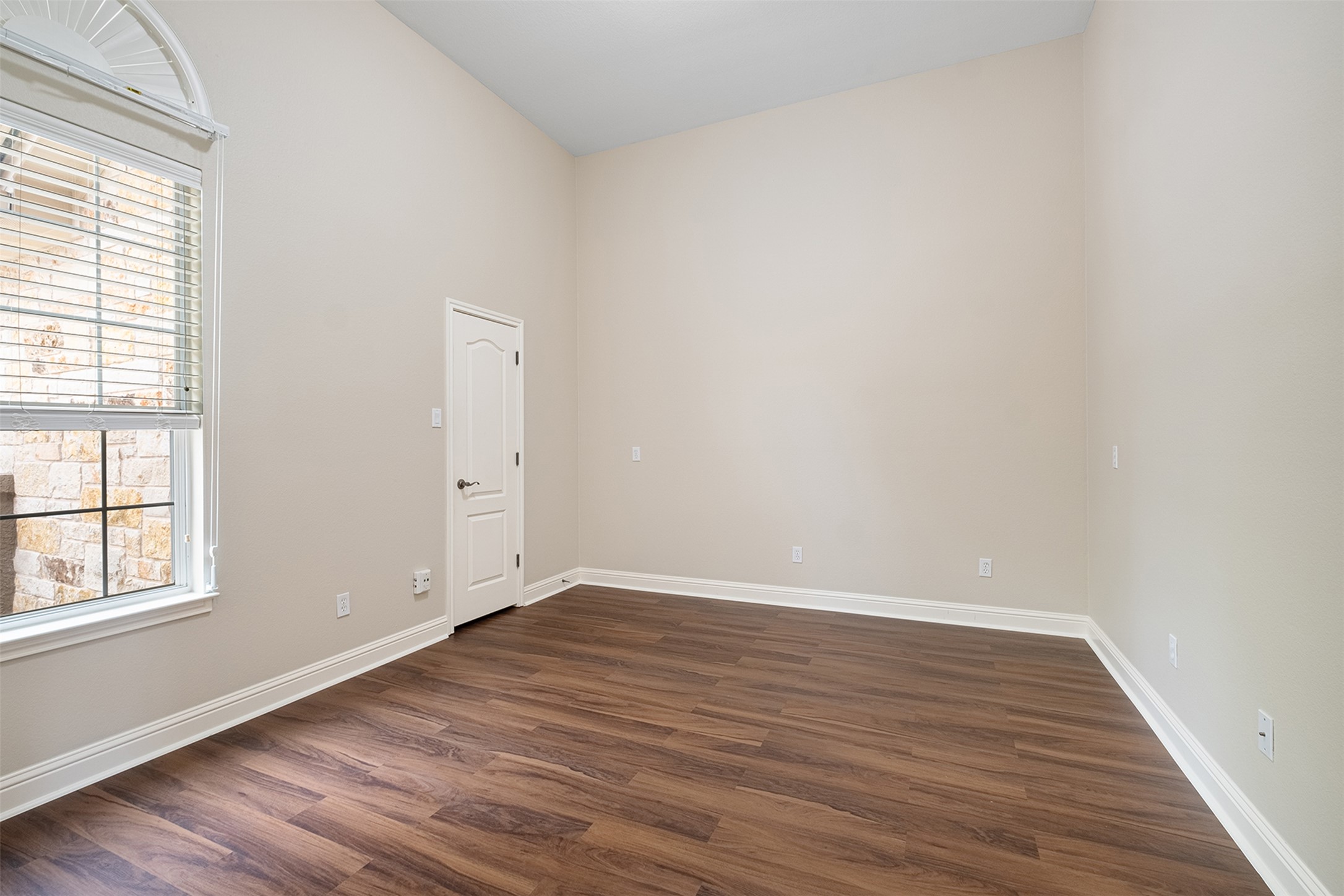 14909 Spillman Ranch Loop Austin, TX 78738 - Photo 18 of 40 Unfurnished room featuring dark wood finished floors, baseboards, lofted ceiling, and plenty of natural light