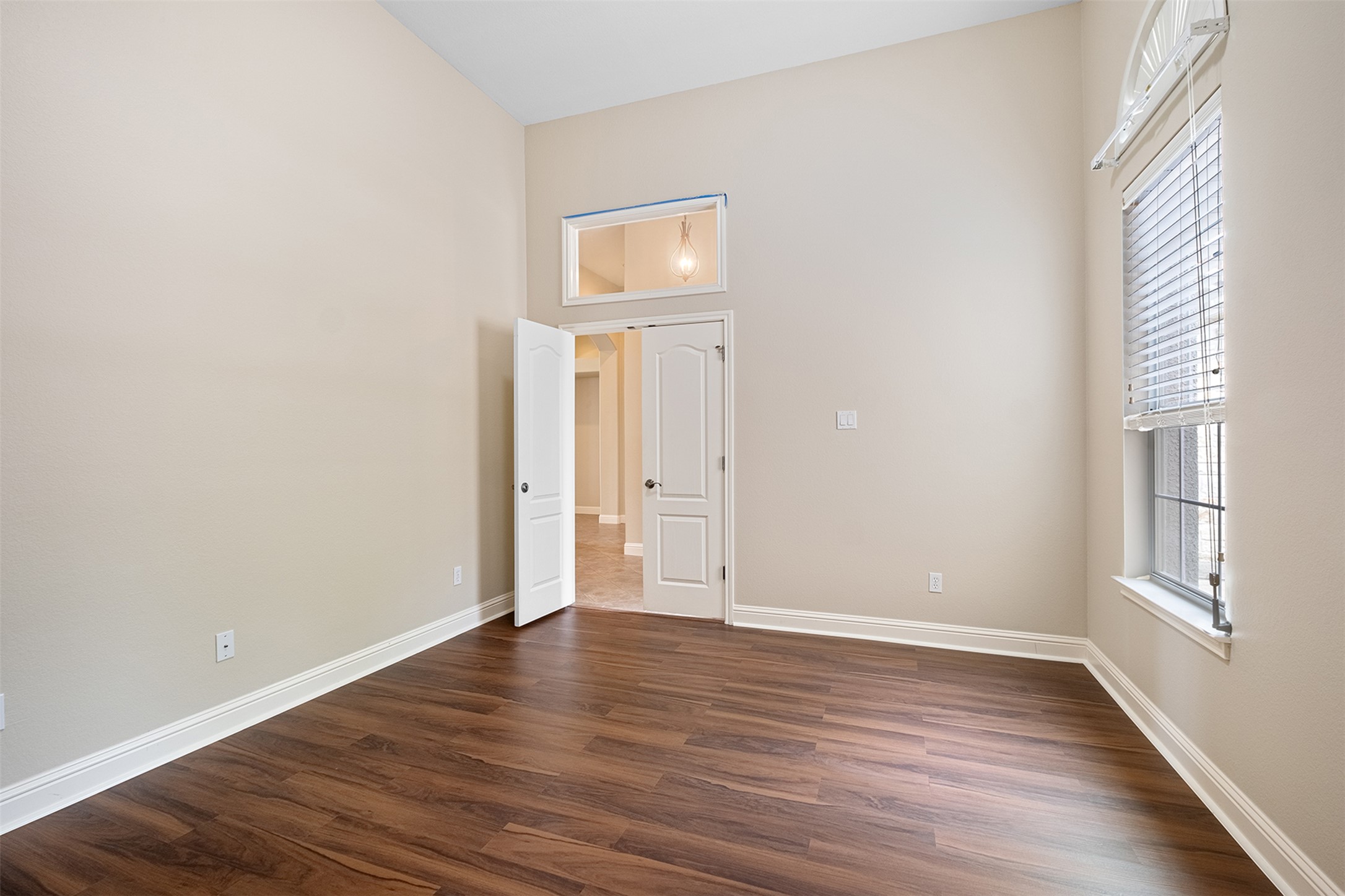 14909 Spillman Ranch Loop Austin, TX 78738 - Photo 19 of 40 Spare room featuring baseboards, a healthy amount of sunlight, and dark wood-style floors