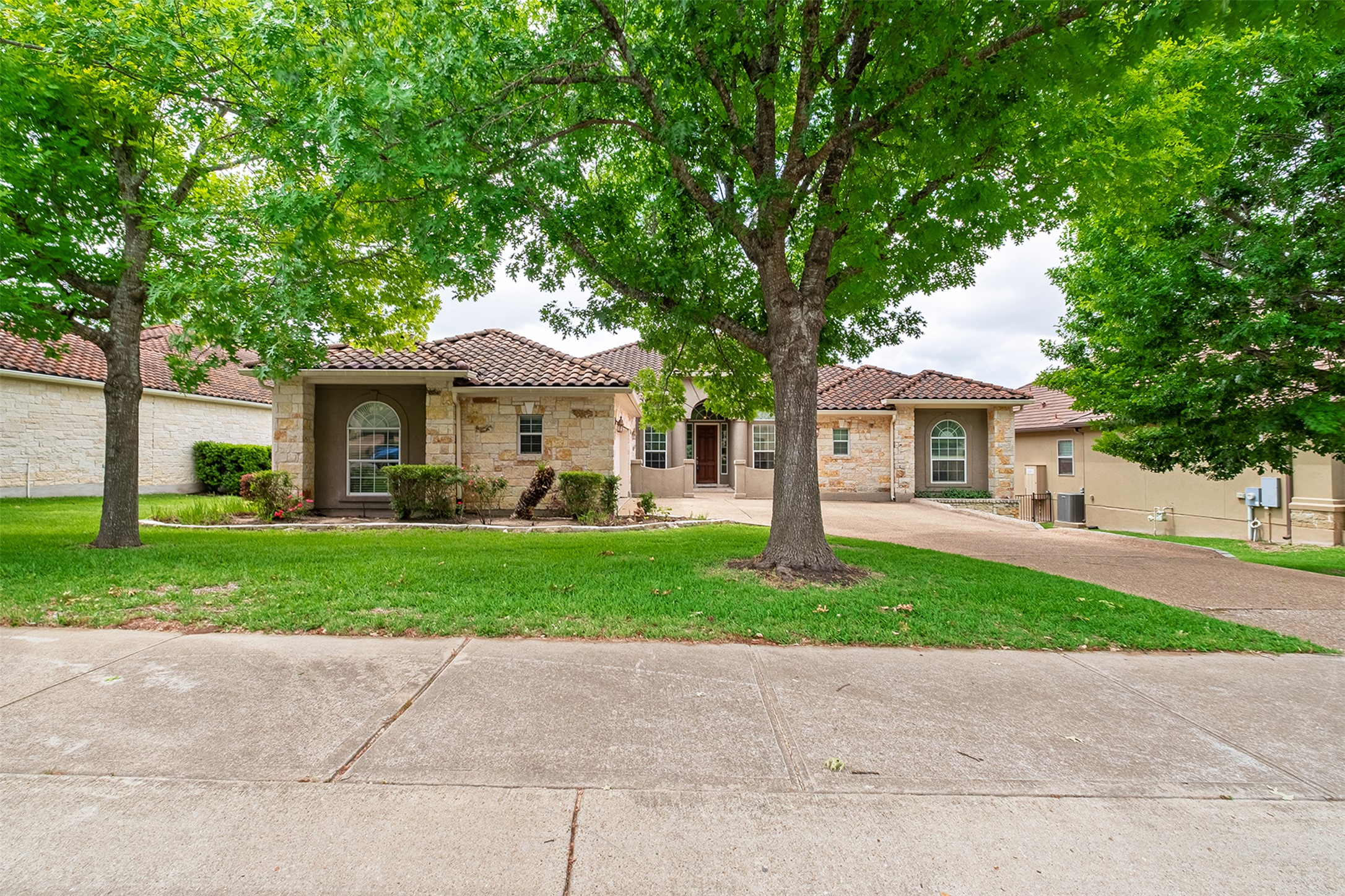 14909 Spillman Ranch Loop Austin, TX 78738 - Photo 2 of 40 Mediterranean / spanish house with stucco siding, a tile roof, stone siding, and a front lawn