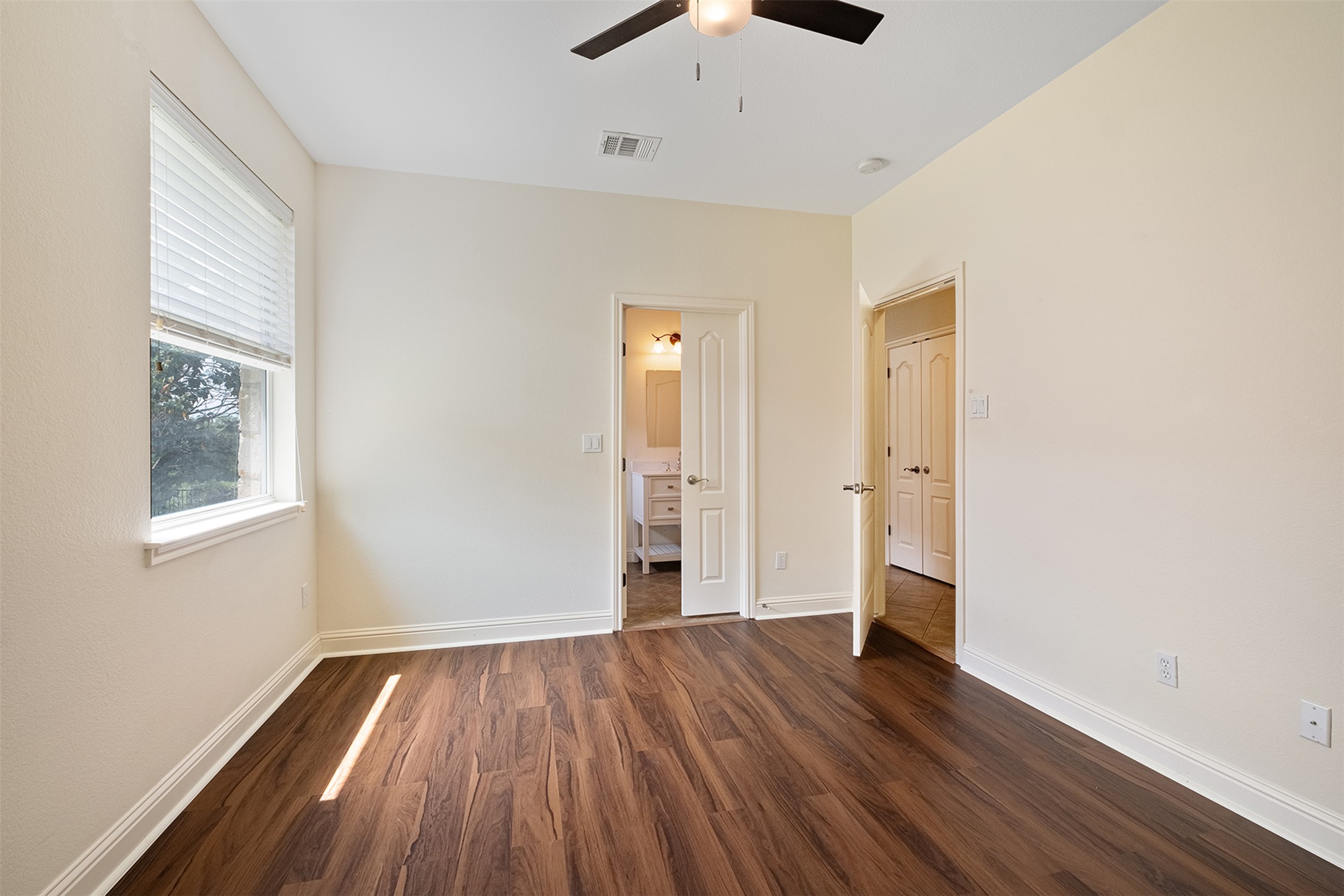 14909 Spillman Ranch Loop Austin, TX 78738 - Photo 22 of 40 Unfurnished bedroom featuring baseboards, visible vents, ceiling fan, and dark wood-style flooring
