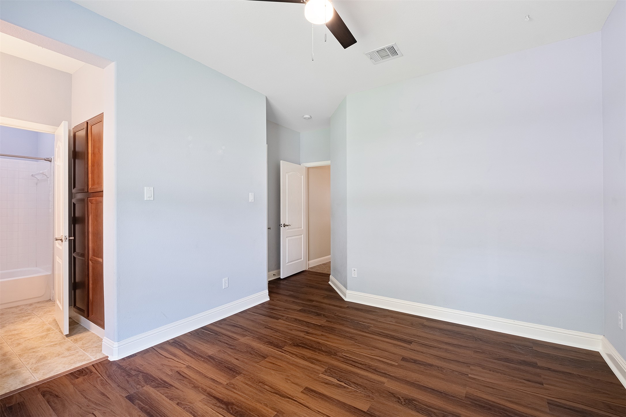 14909 Spillman Ranch Loop Austin, TX 78738 - Photo 27 of 40 Unfurnished bedroom featuring dark wood finished floors, visible vents, baseboards, and ceiling fan