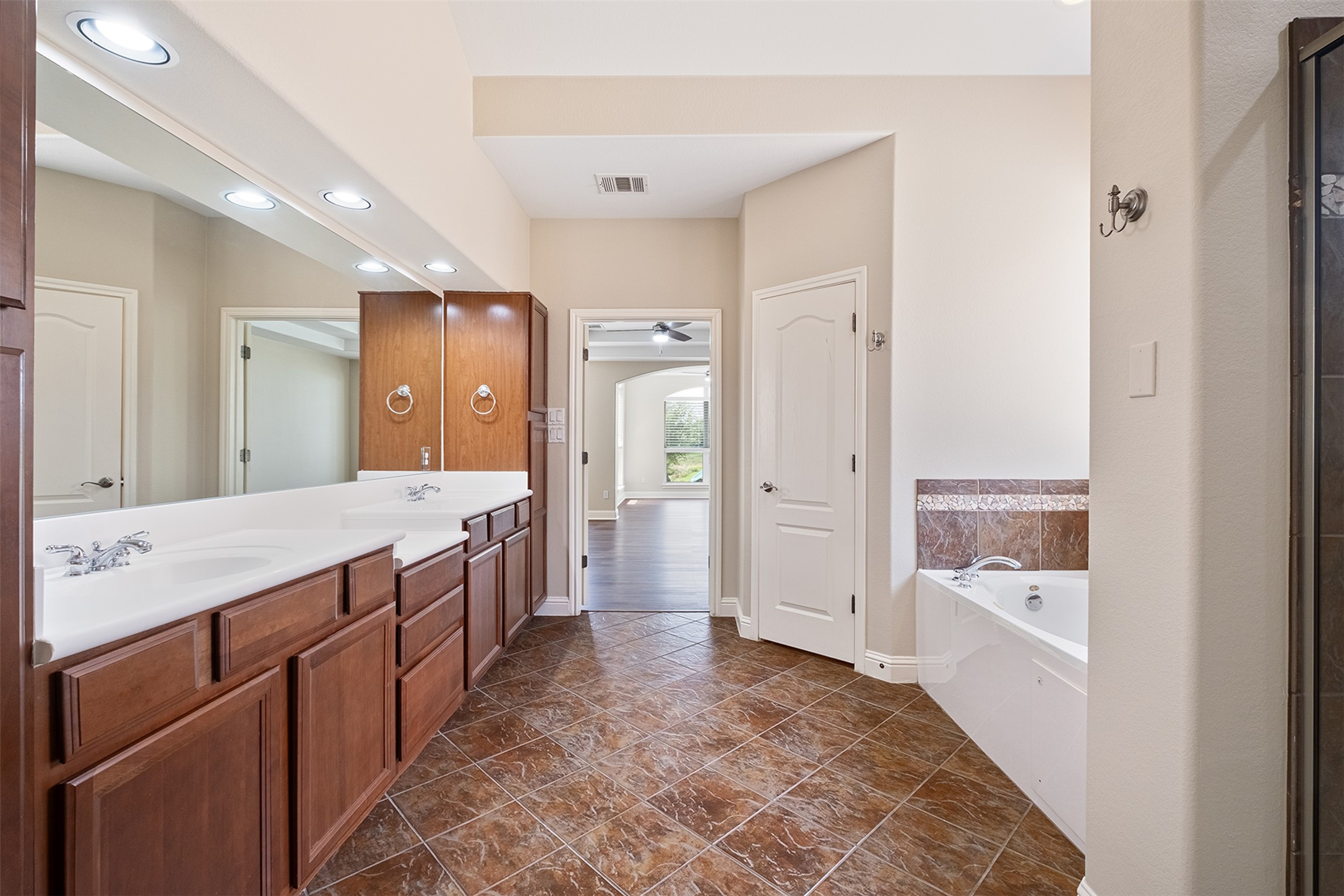 14909 Spillman Ranch Loop Austin, TX 78738 - Photo 33 of 40 Full bath with recessed lighting, double vanity, visible vents, a bath, and baseboards