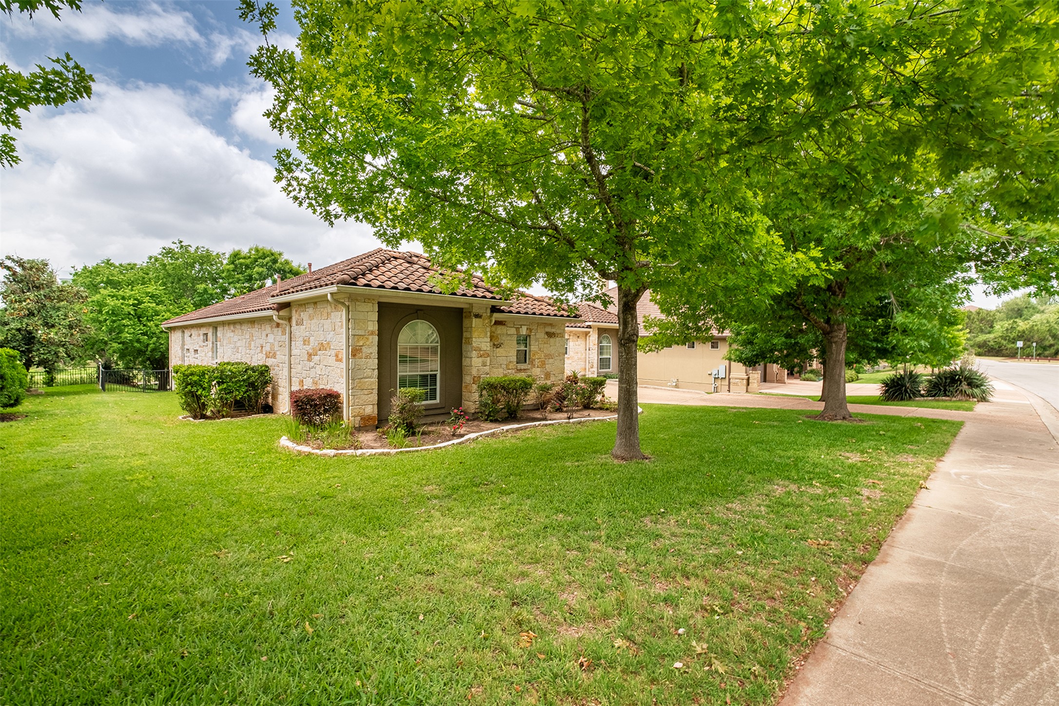14909 Spillman Ranch Loop Austin, TX 78738 - Photo 4 of 40 Mediterranean / spanish house featuring a tile roof, stone siding, and a front yard