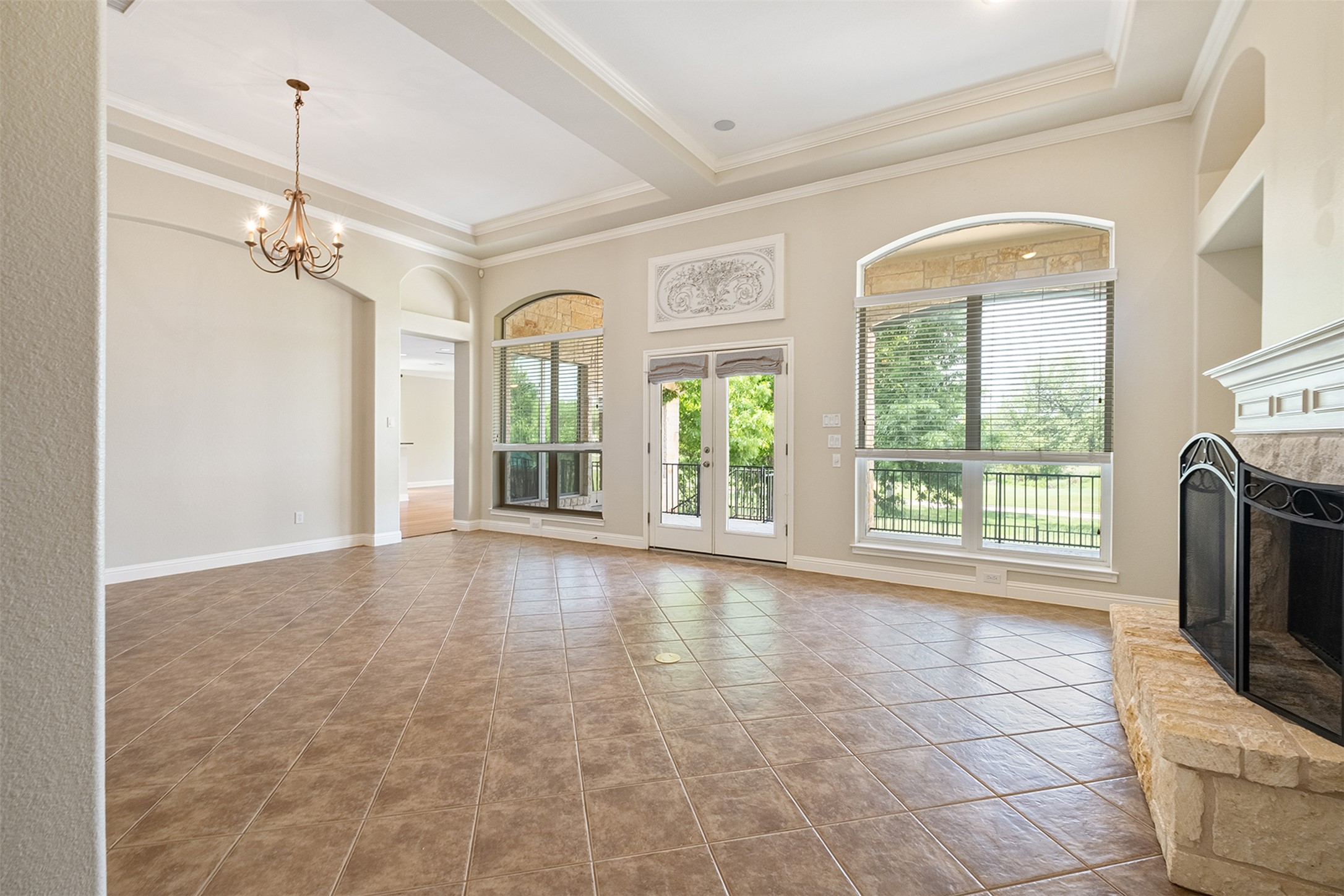 14909 Spillman Ranch Loop Austin, TX 78738 - Photo 8 of 40 Unfurnished living room featuring built in features, a fireplace, a chandelier, and ornamental molding