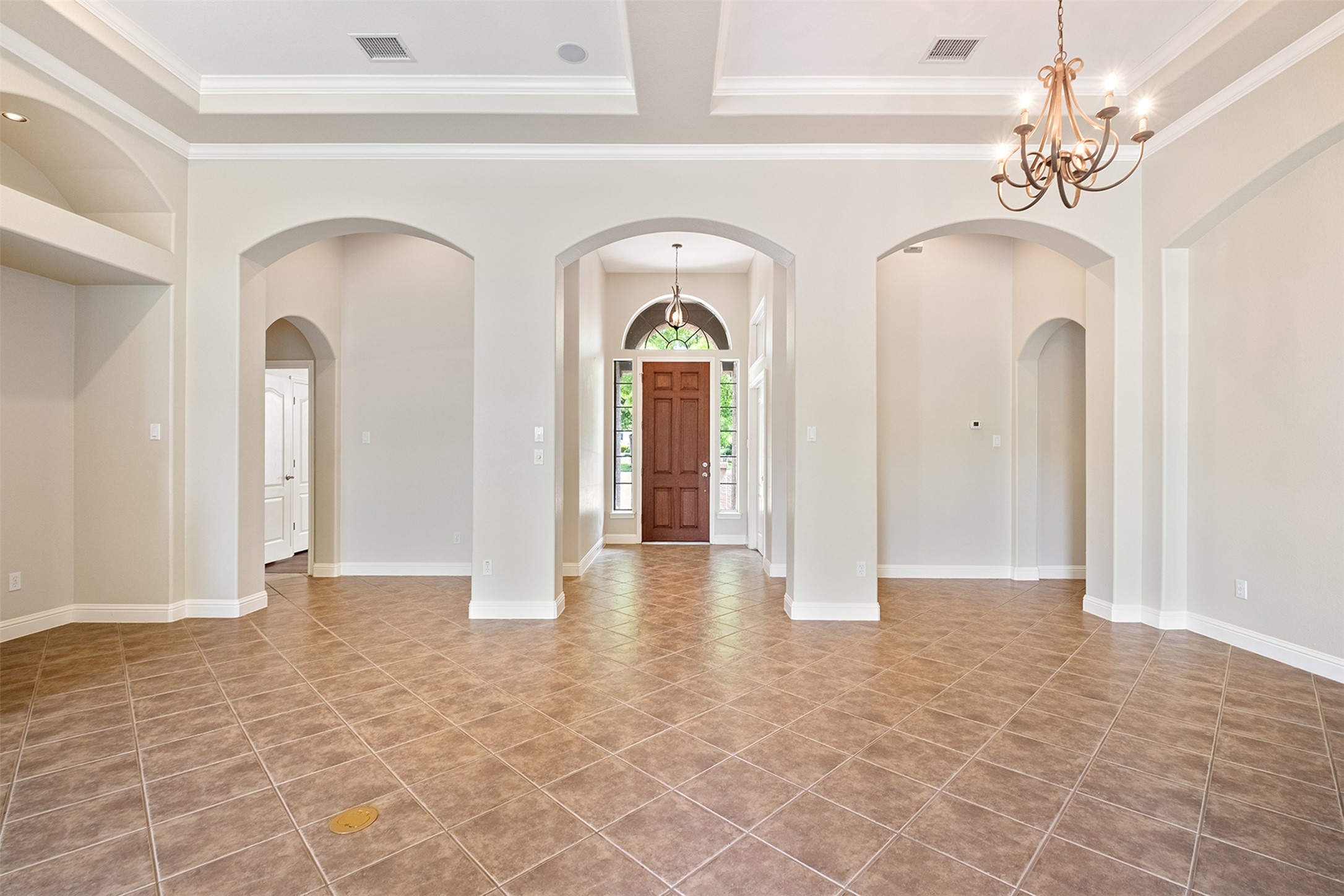14909 Spillman Ranch Loop Austin, TX 78738 - Photo 9 of 40 Tiled foyer with a raised ceiling, a notable chandelier, ornamental molding, and visible vents