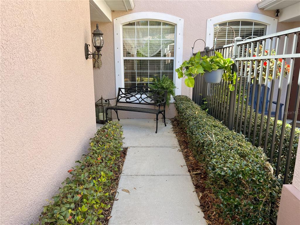 a balcony with couple of flower plants and wooden fence