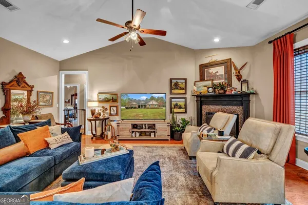 a living room with furniture a ceiling fan and a rug