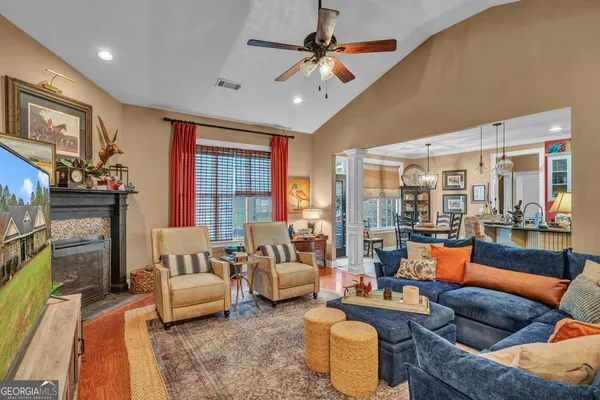a living room with furniture a flat screen tv and a large window