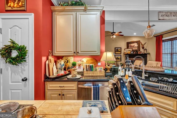 a front view of a kitchen with stainless steel appliances granite countertop a refrigerator and a stove top oven