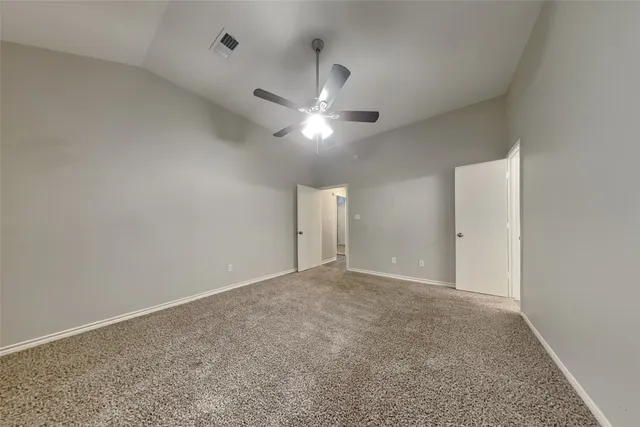 an empty room with closet and a ceiling fan
