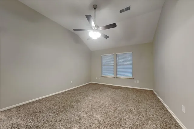 an empty room with a window and ceiling fan