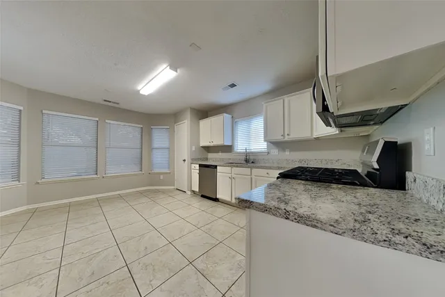 a kitchen with stainless steel appliances granite countertop a sink stove and cabinets