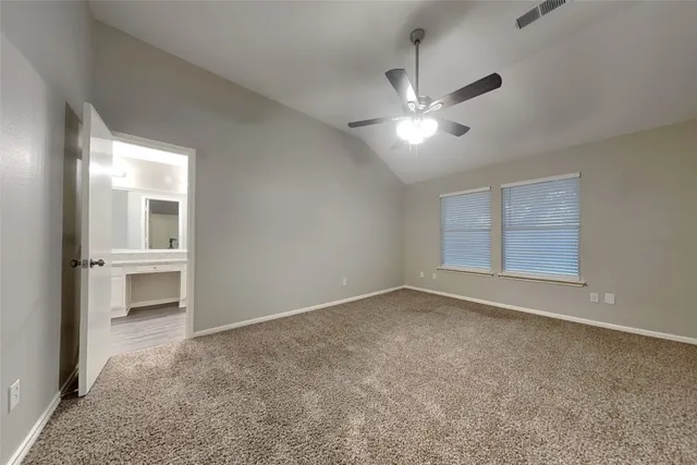 a view of an empty room with a ceiling fan and window