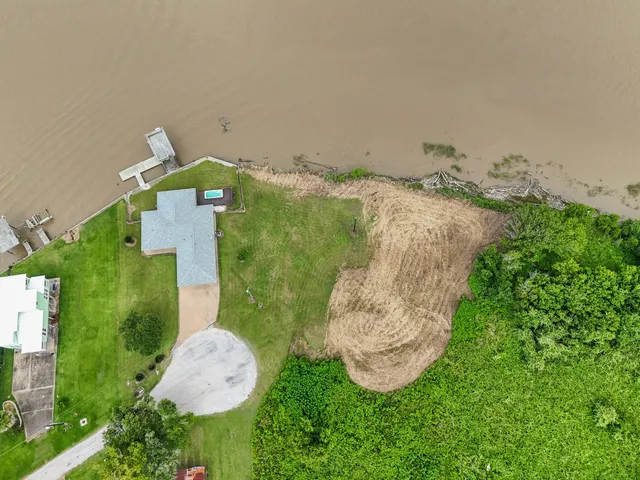 an aerial view of a house with a yard and lake view
