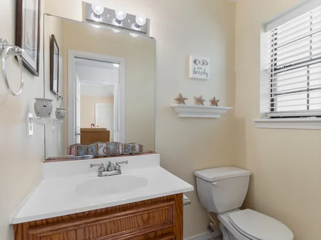 a bathroom with a granite countertop toilet sink and mirror