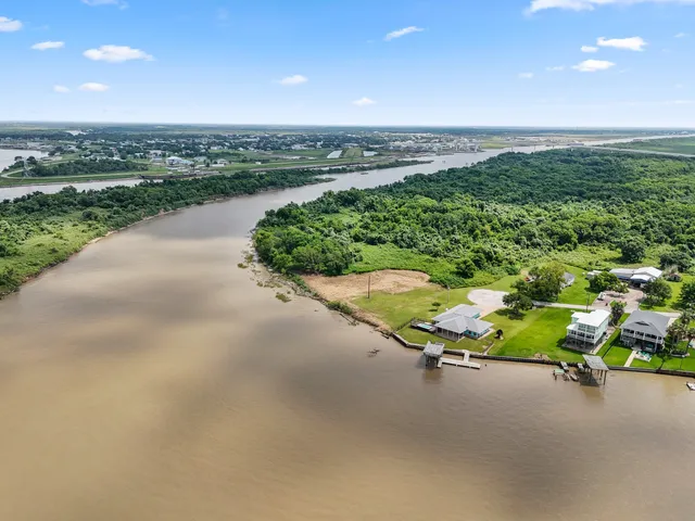 an aerial view of a swimming pool with a yard and lake view