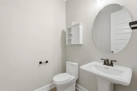 a bathroom with a sink a toilet and mirror