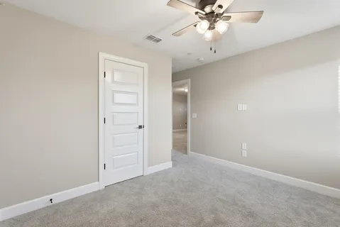 an empty room with closet and a chandelier fan
