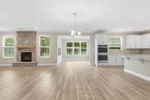 a view of empty room with wooden floor and fireplace
