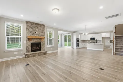 a view of empty room with wooden floor and fireplace