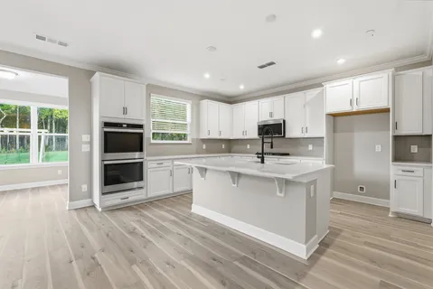 a kitchen with stainless steel appliances granite countertop a stove a sink and a microwave