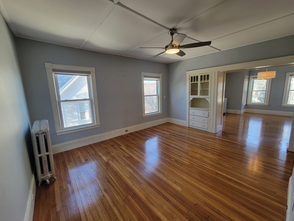 100 Medford Street, Unit 2 Malden, MA 02148 - Photo 12 of 29 a view of an empty room with wooden floor and a window