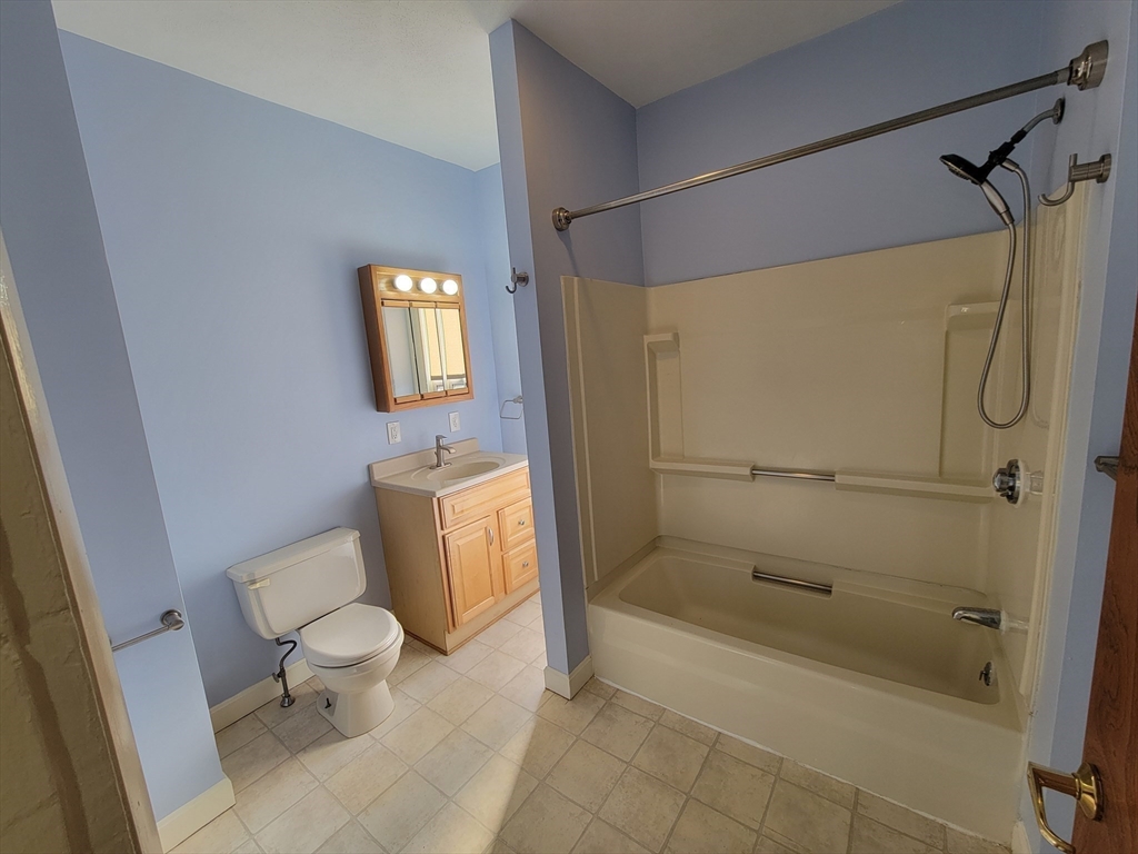 100 Medford Street, Unit 2 Malden, MA 02148 - Photo 15 of 29 a bathroom with a granite countertop toilet and a shower