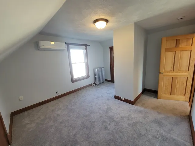 an empty room with closet and a window